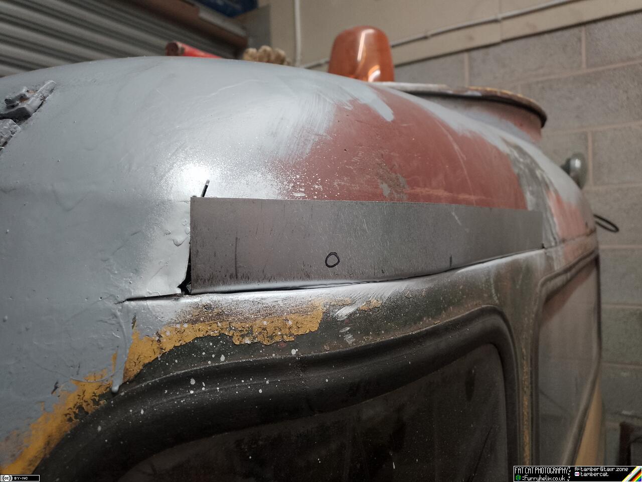 Curved piece of metal bent up to fit in the hole where metal was cut out